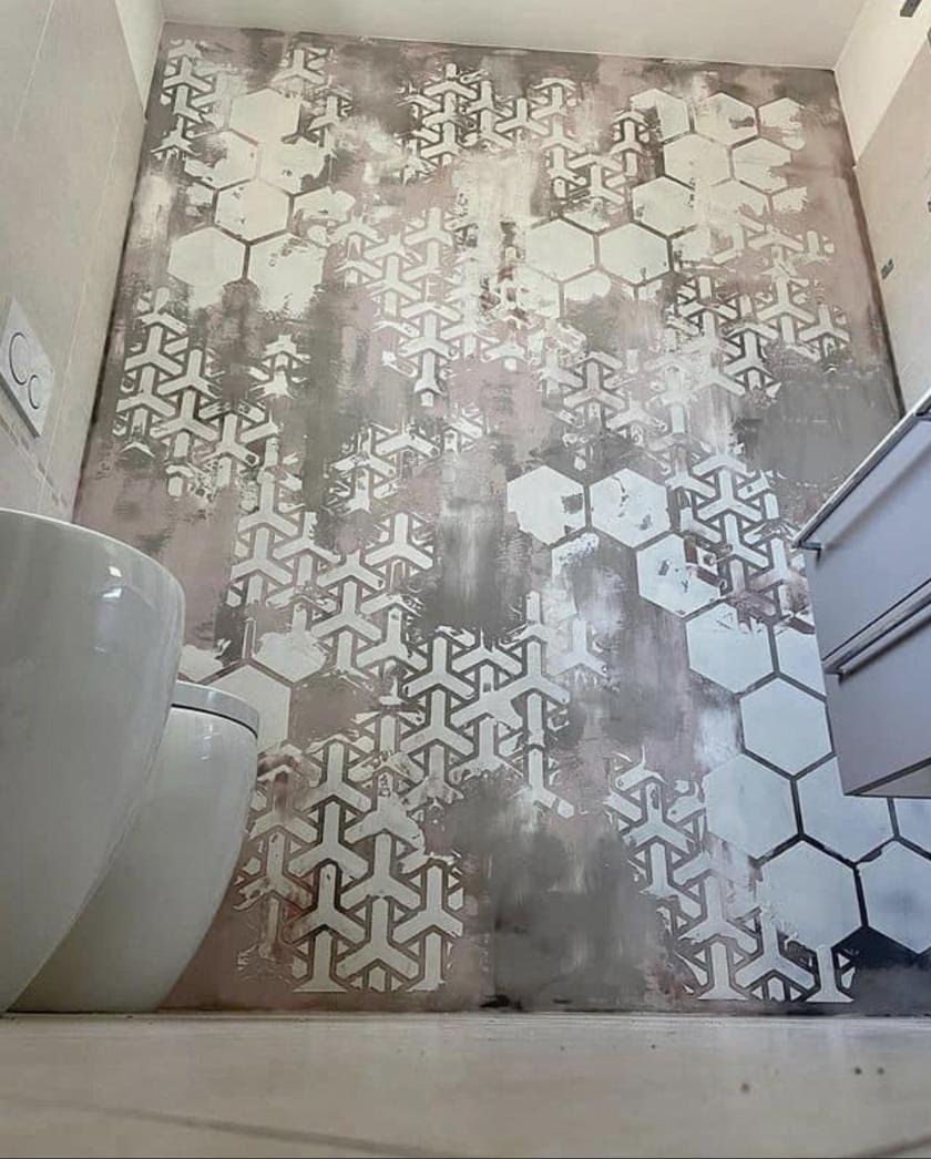 Detalle de una pared de baño con acabado decorativo de hexágonos y figuras geométricas