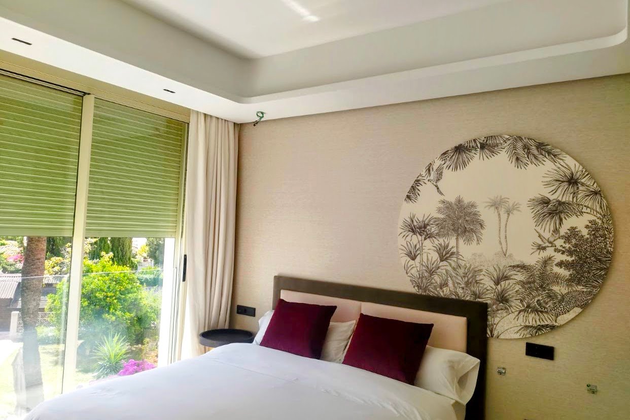 Dormitorio reformado en Marbella con falso techo de placas de yeso y papel pintado tropical - Trabajo de PintaReformas