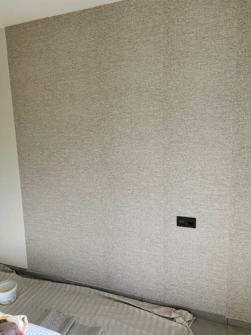 Pared con papel pintado de efecto tejido y el suelo protegido con una tela