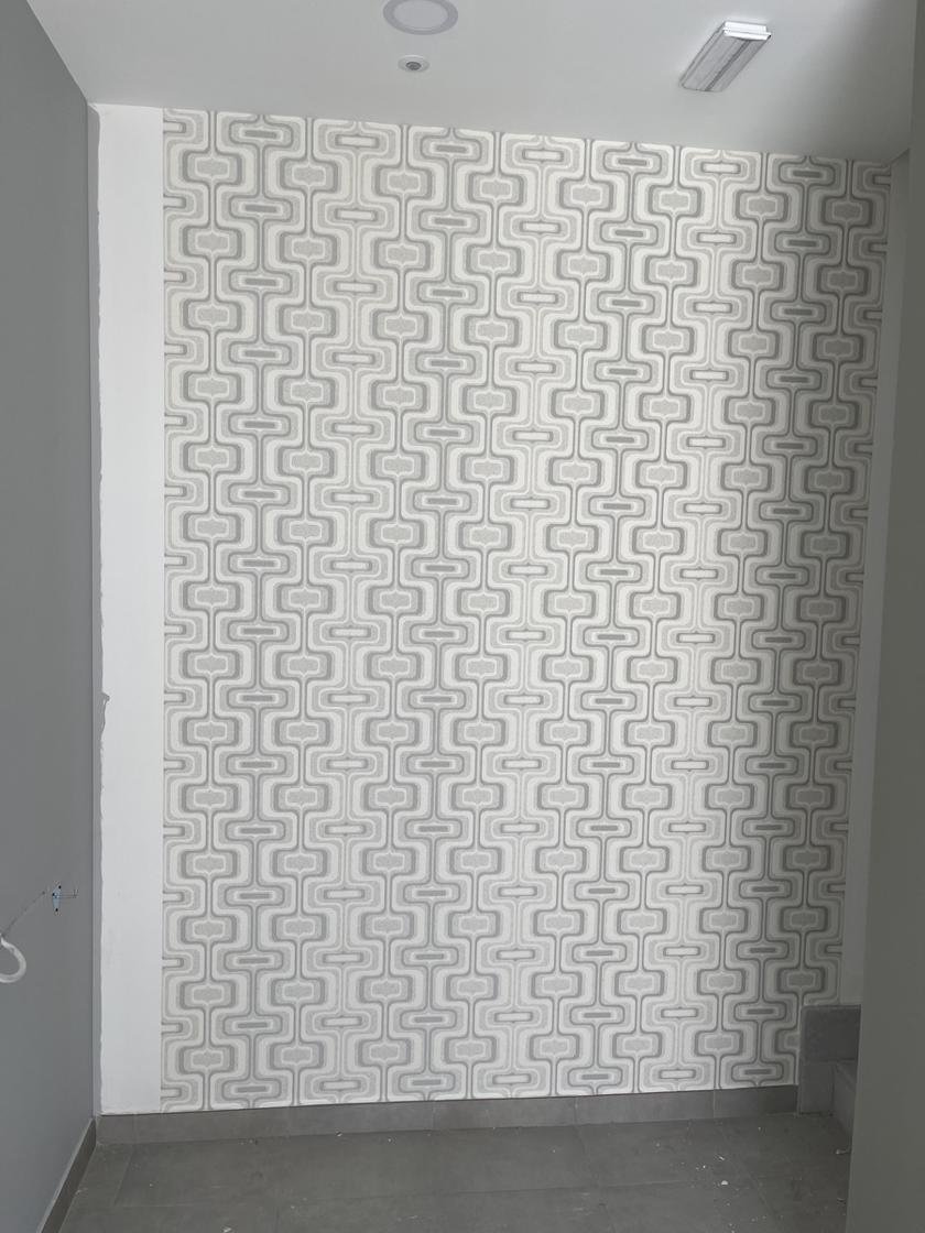 Pared con papel pintado de diseño geométrico en tonos grises y blancos