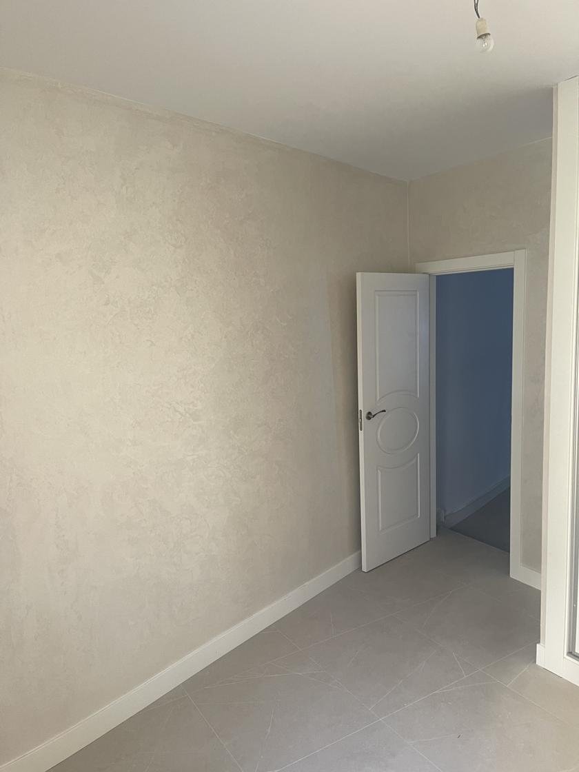 Pared con pintura decorativa efecto damasco junto a una puerta blanca
